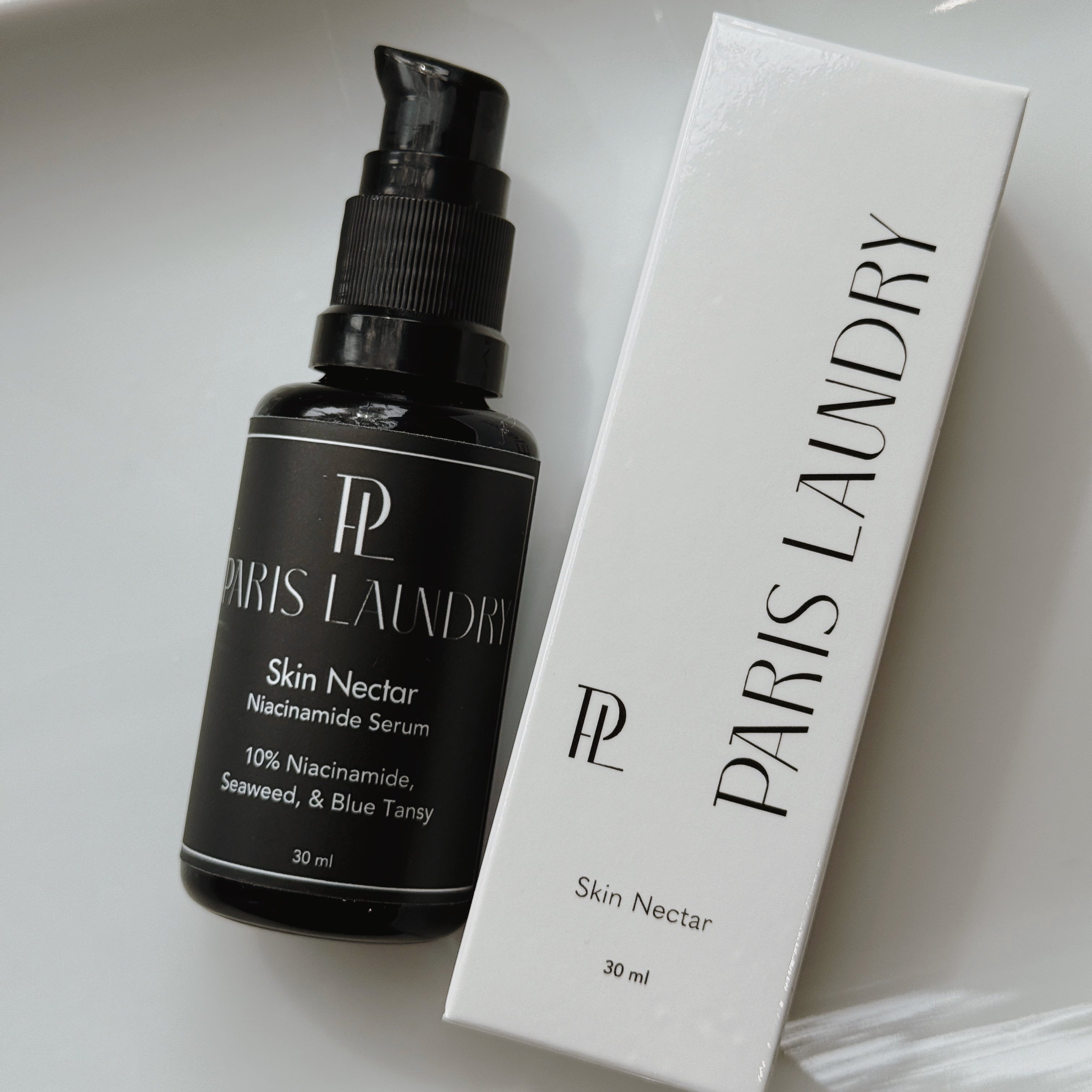 Paris Laundry Skin Nectar serum bottle and packaging on a white surface